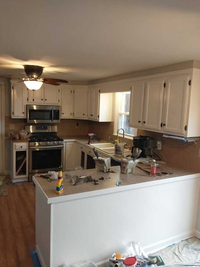 Kitchen cabinets after repainting in a lighter finish with tools still visible