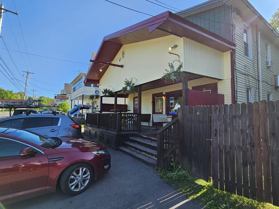 Exterior painting project photographed from an angle with fresh trim and siding visible