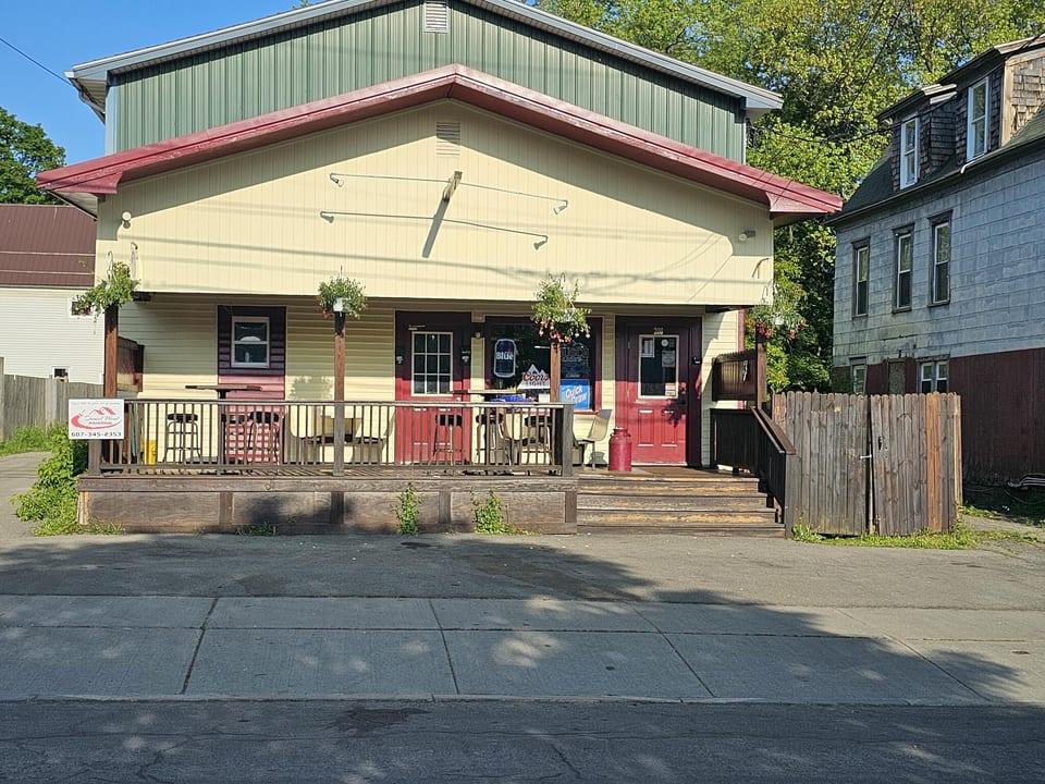 Front view of an exterior painting project with red trim and a light painted facade
